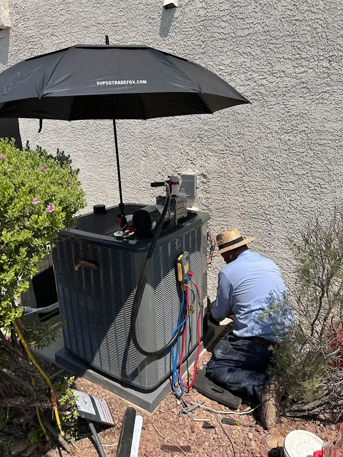HVAC technician performing outdoor AC maintenance in Dickinson